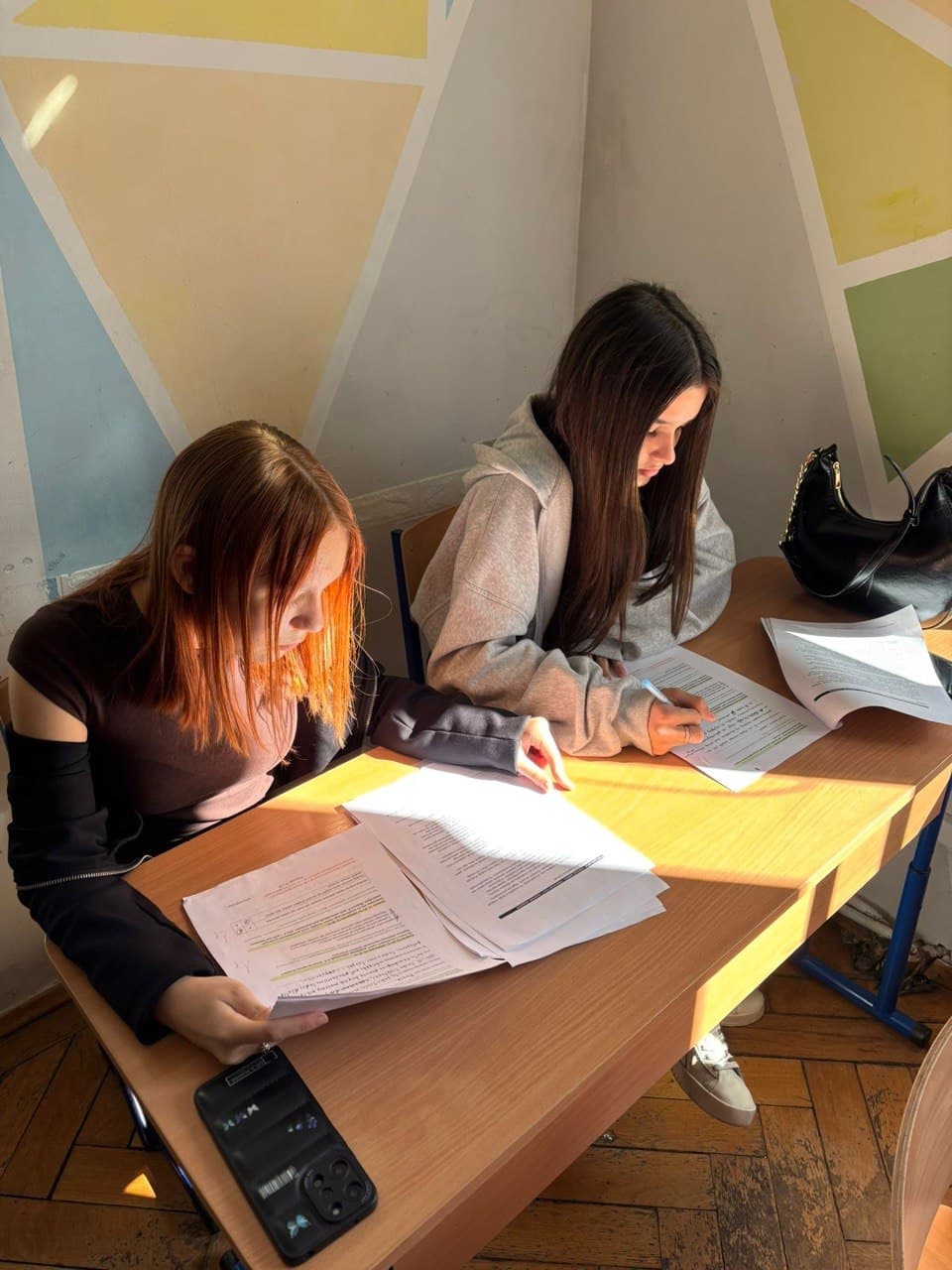 Учениці працюють із навчальними матеріалами за столом